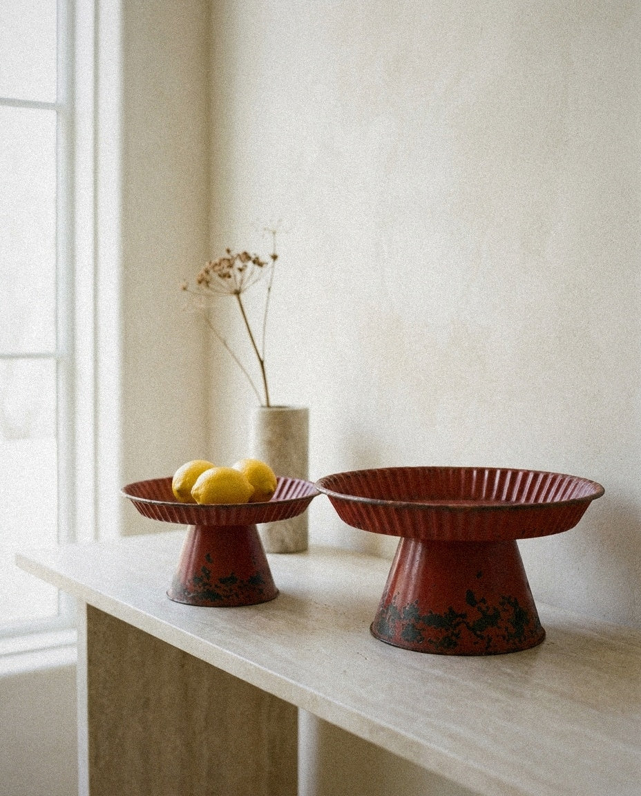 Decorative Metal Pedestals -Distressed Red Finish styled in a minimal, sunlit room