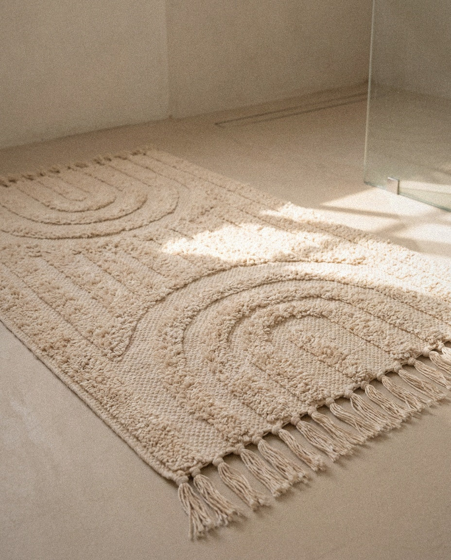 Close-up of the tufted arch pattern and hand-knotted tassels of the Hana bath mat