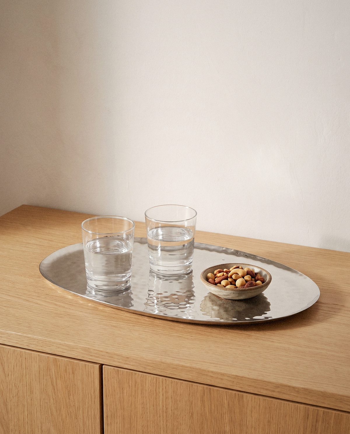Polished Steel Oval Serving Tray detail in warm natural light